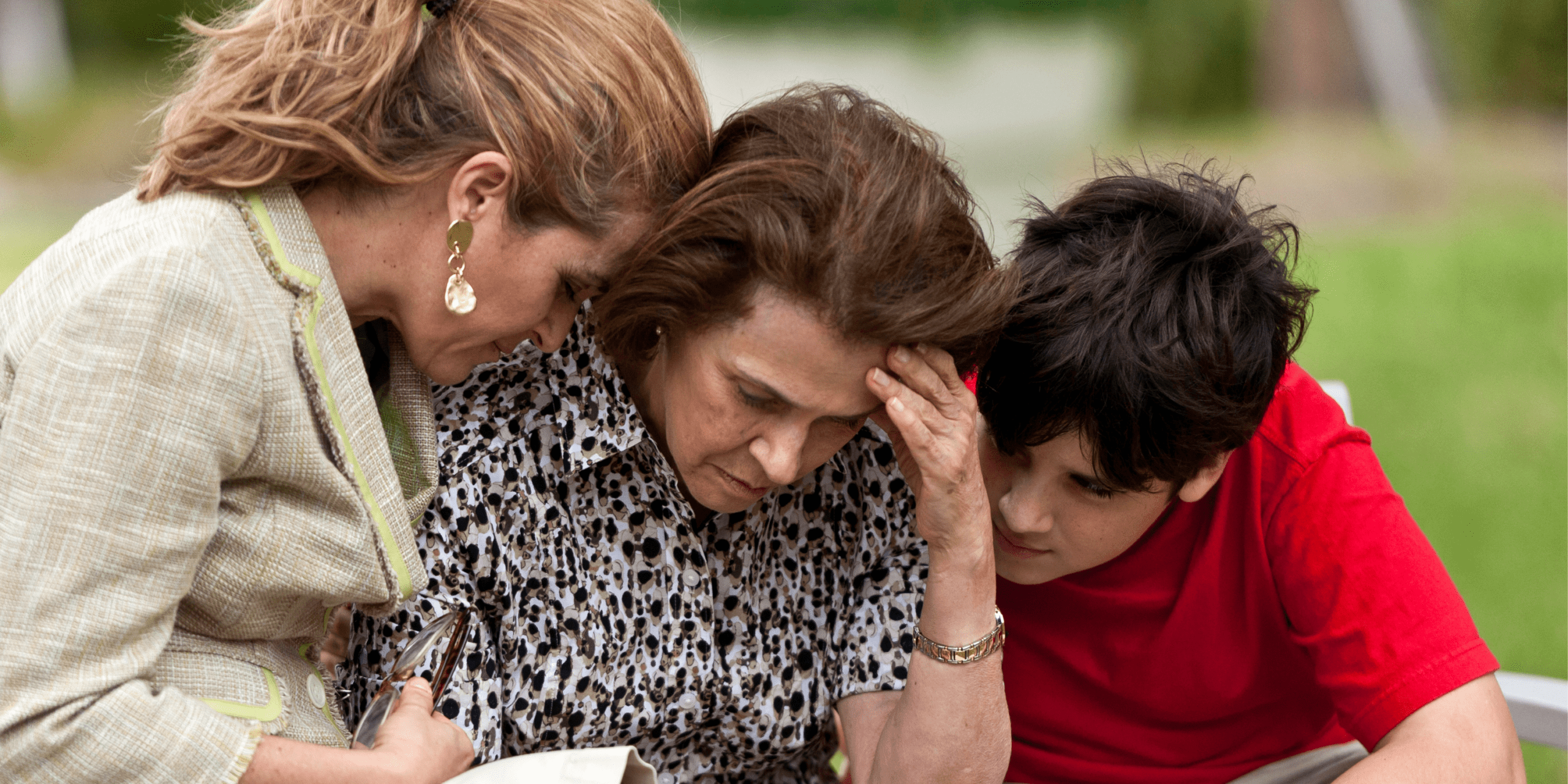 Femme et garçon qui consolent une femme âgée sur un banc