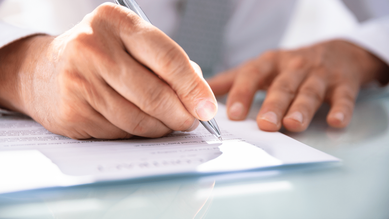 main avec stylo sur papier